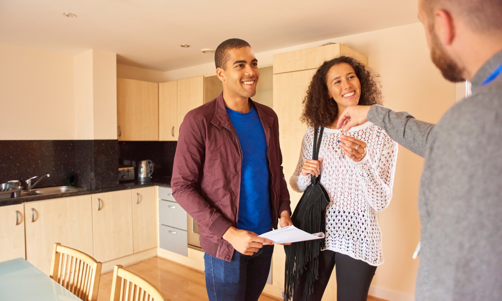 Real estate agent handing keys to military family in Fort Bragg home